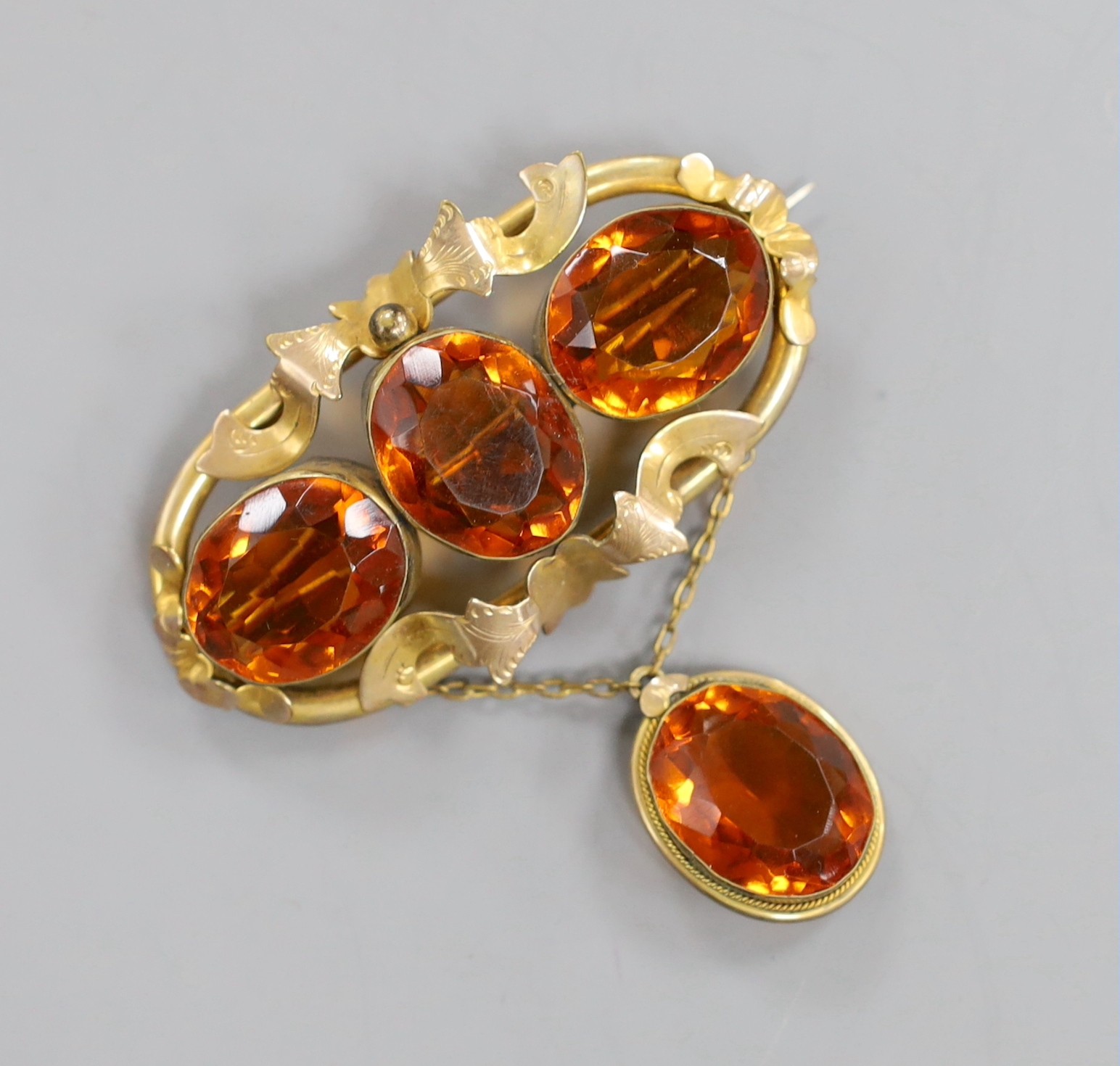 A Victorian pinchbeck and four stone oval cut citrine set drop brooch, width 64mm.
